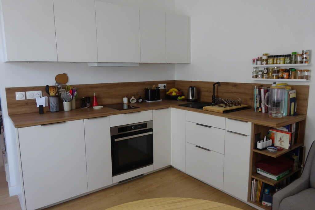 petite cuisine blanche pour appartement avec plan de travail et crédence en bois mélaminé