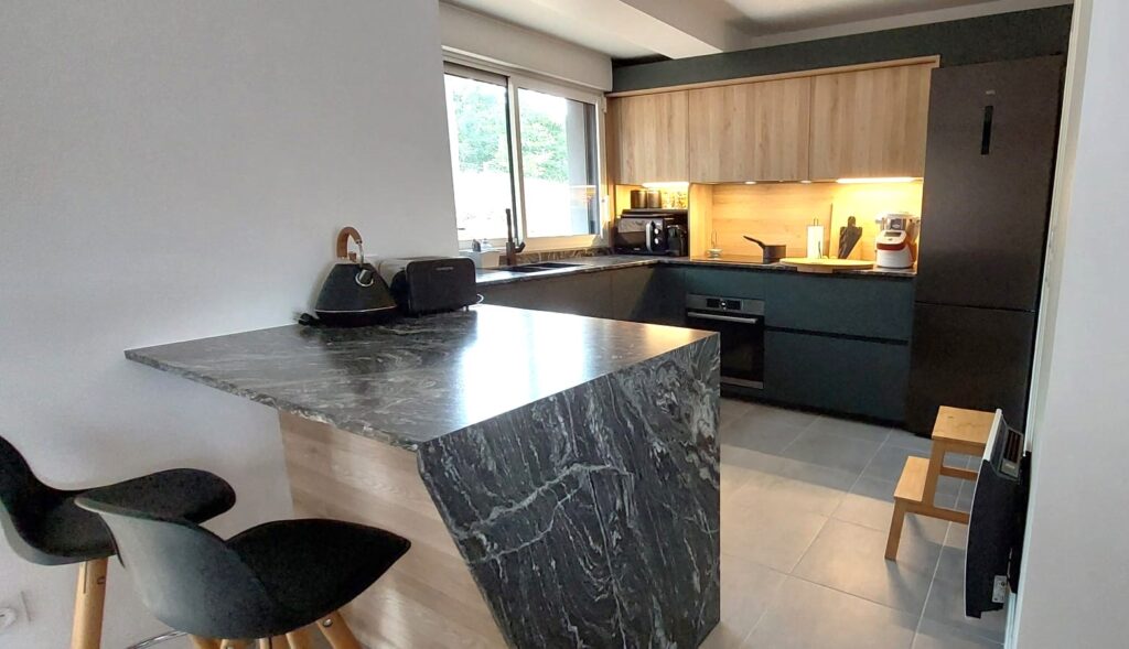 Cuisine vert et bois - plan de travail granit noir et blanc