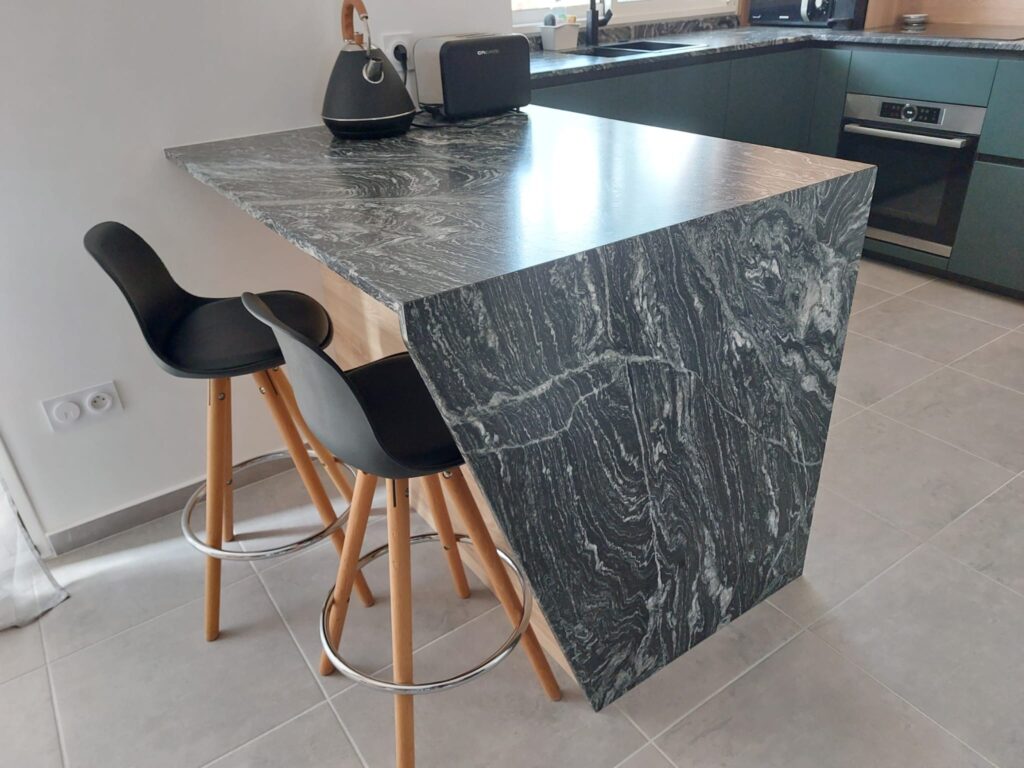 ilot granit noir et blanc avec jambage en biais. assise deux personnes.